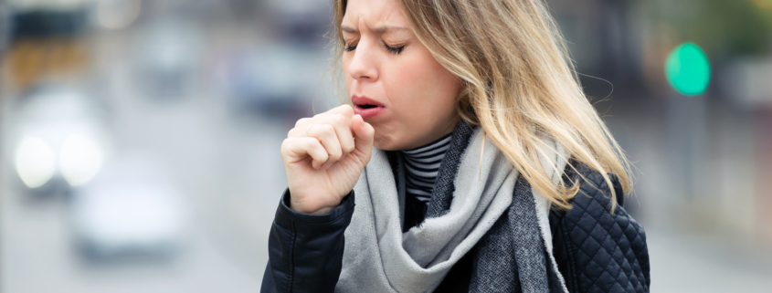 An image of a woman coughing into her fist,