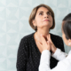 An image of a doctor feeling a patient's throat for dyphagia.